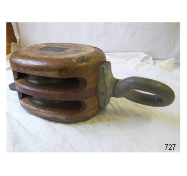 Wooden two sheave rope block with metal pulley wheels and loop fitting. Rectangular compliance plate.