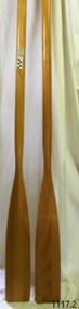 Flat ended oars of light coloured wood with varnished coat