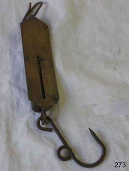 Brass scale with suspension ring on top and hook on bottom