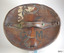 Lid showing remnants of labels, stamped initials. Two leather tags are stitched on , with a curved leather opening on one side.