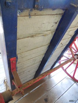 Metal axel is joined to cart's base with brackets