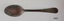 Teaspoon has text stamped on handle