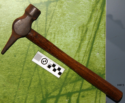 Wooden handle and metal head, rounded end on one side, tapered end on the other side