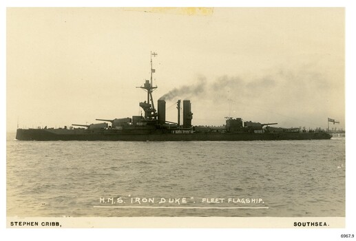 Sepia photograph of a battleship, smoke coming from funnel