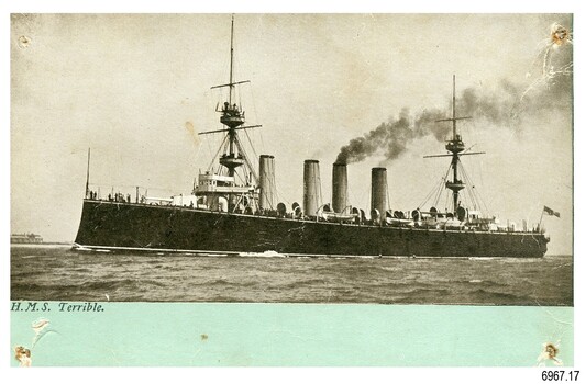 Battleship in black and white photograph with green bottom border