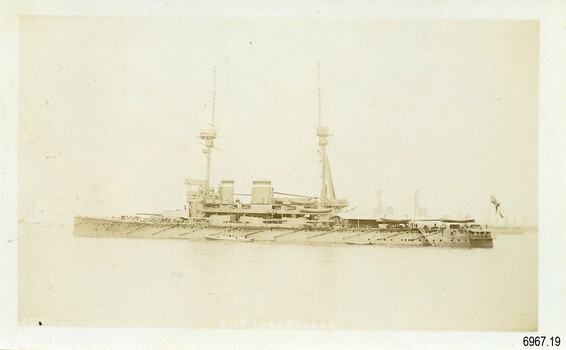Battleship HMS LORD NELSON ailing in fog, flag outstretched above stern, sepia photograph