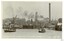 Ships in industrial area along a river, black and white photograph