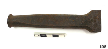 Tool has round top, shaped shank that flares to base with straight edge