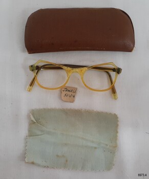 The brown case contained the spectacles, a cleaning cloth and a price tag.