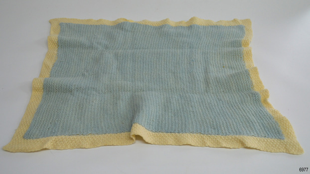 Blanket is lined with blue knitted rectangle