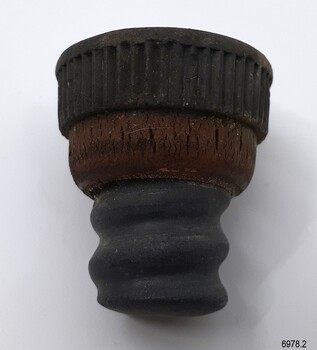 Top of stopper is Bakelite, centre is cork, tip is moulded ruber