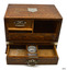Tambour door is partly open revealing two hidden drawers and a shelf