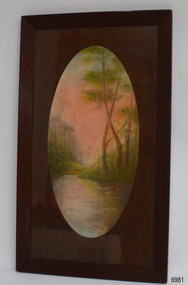 Rectangular wooden frame with oval wooden matt framing scene of river, hills and trees 