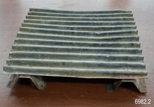 Corrugated iron stand has short legs to raise it above the surface
