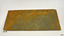 Two holes are drilled through tile, that has orange-brown stain over blue-grey colour.