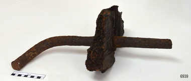 Wood sample has a ship's nail through it