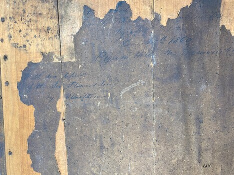 Back of the frame with handwritten inscriptions in black ink