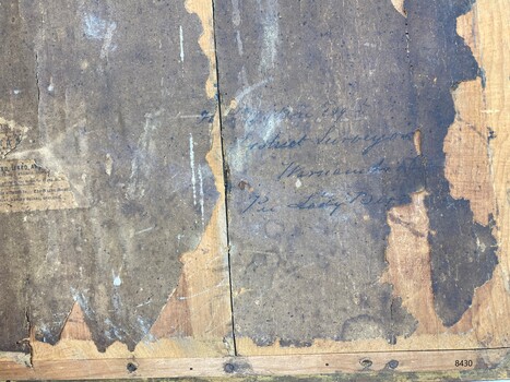 Back of the frame with handwritten inscriptions in black ink