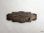 Badge has a long pin for attaching it, and embossed lettering.