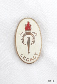 Gold metal and white enamel badge with symbol of flaming torch