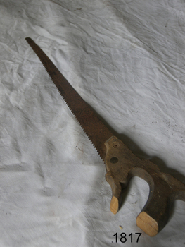 Saw has a wooden handle and long blade with small teeth