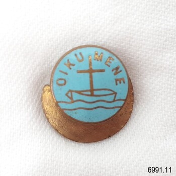 Round badge, gold metal and aqua enamel, with logo of boat, cross and waves