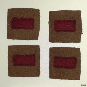 Four cloth patches, red rectangles on brown squares