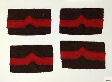 Four cloth patches with Medical Corps Insignia. Red on brown fabric.