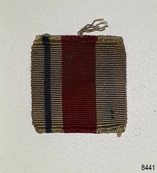 Ribbon has vertical stripes; a narrow blue stripe and wide red stripe