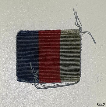 Cloth ribbon has vertical stripes of blue and red or crimson
