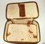 Tan coloured leather pouch with zipper. Straps inside the lid.