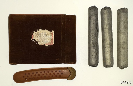 Case with long narrow cover, and three grey fabric covered tubes
