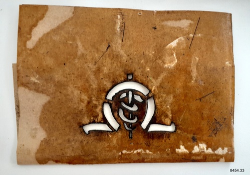 Stencil on waxed heavy weight paper. It has the cutout symbol of the medical logo with an arch above it