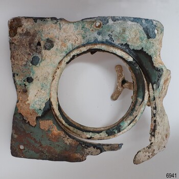 Square metal frame with a band round a central opening. The frame has formed holes. A handle is visible.