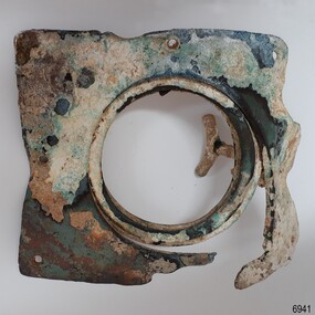 Square metal frame with a band round a central opening. The frame has formed holes. A handle is visible.
