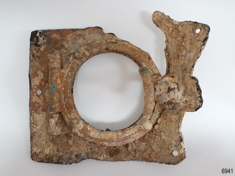 Frame has hinge on the left and handle on the right. The square panel has formed holes. It is encrusted.