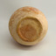 Round base has uneven edges, concentric circles and pinhole marks in a pattern