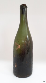Tall green glass handmade bottle with stopper in place