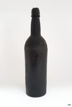 Tall black glass bottle with bulbous neck and side seams