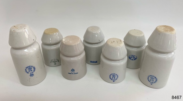 White porcelain insulator with blue manufacturer stamp shown from above