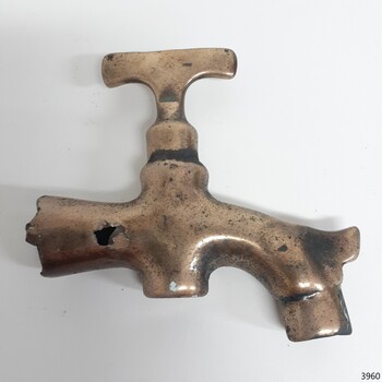 Brass tap, flat handle, horn on spout, drilled hole through pipe, severed end