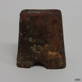 Brown and encrusted metal cow bell, upright, without handle, arch cut in bottom edge