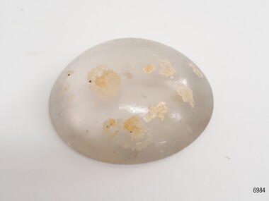 Clear glass dome with encrustations and scratches on the surface, bubbles in the glass