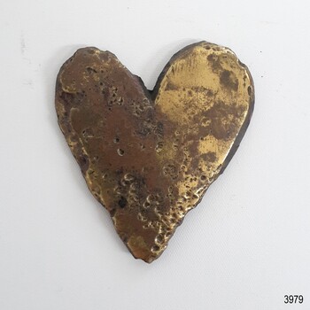 Polished brass decoration, heart shaped. Pitted surface with scratches