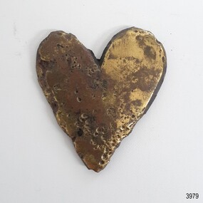 Polished brass decoration, heart shaped. Pitted surface with scratches