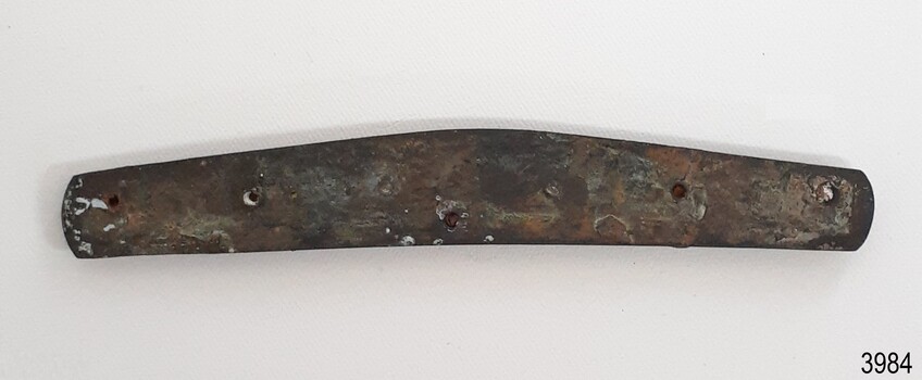 Drilled holes are spaced along the corroded knife