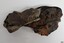 Concretion of matter with handles of metal spoons visible