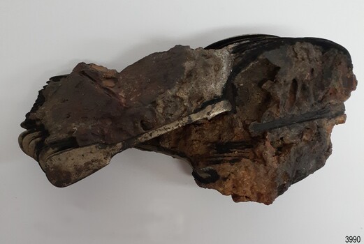 Concretion of matter with handles of metal spoons visible