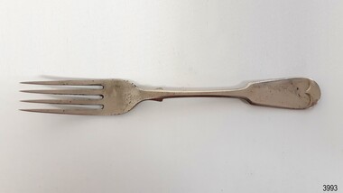 Silver metal fork has collar and decorative handle