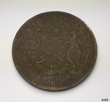 Round metal coin with the Australian Coat of Arms on it. 